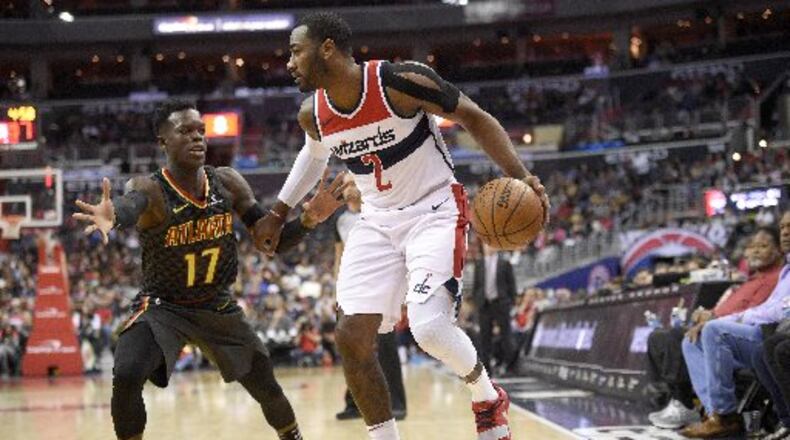 Wizards guard John Wall drives against Dennis Schroder.
