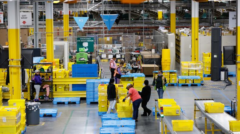 Amazon employees work at the Transfer-Out section at a distribution center in Stone Mountain, where packages are prepared for delivery to other Amazon warehouses on Monday, December 2, 2024. (Miguel Martinez / AJC)