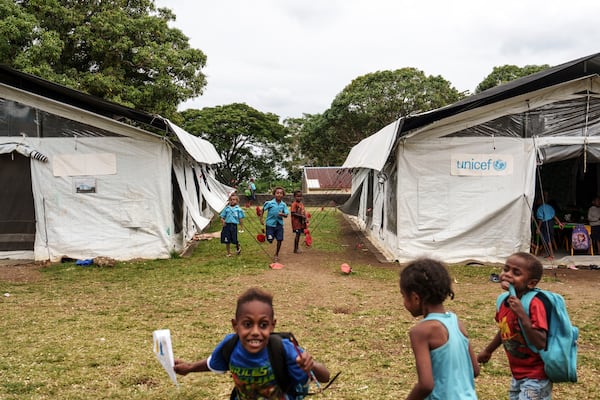 Students play outside tented classrooms at Sainte Jeanne D'Arc school in Port Vila, Vanuatu, Thursday, July 17, 2025. (AP Photo/Annika Hammerschlag)
