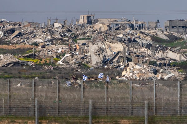 Israeli flags placed on some destroyed buildings in the northern Gaza Strip as seen from southern Israel, Wednesday, March 5, 2025. (AP Photo/Ariel Schalit)