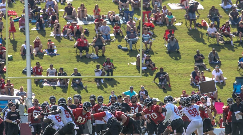 Fans watch the Atlanta Falcons during a play at training camp, Saturday, July 28, 2018, in Flowery Branch, Ga.