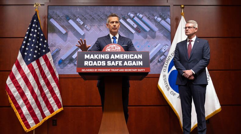 Transportation Secretary Sean Duffy speaks as Derek Barrs, Administrator of the Federal Motor Carrier Safety Administration, listens during a news conference at the Department of Transportation in Washington, Friday, Dec. 12, 2025. (AP Photo/Mark Schiefelbein)