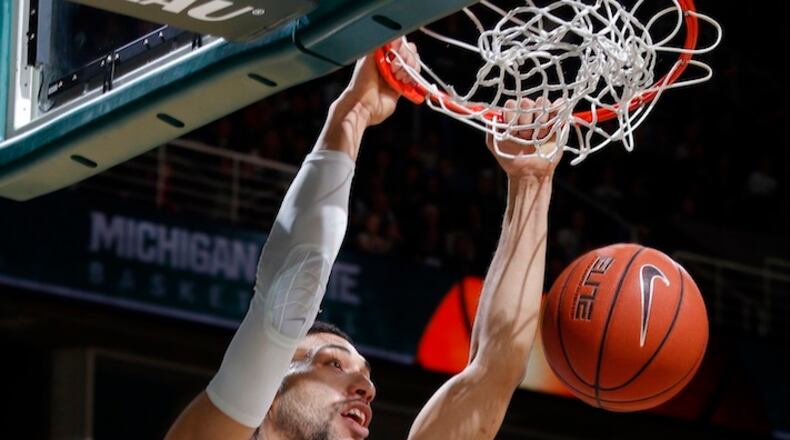 FILE - In this Dec. 9, 2015, file photo, Michigan State's Denzel Valentine dunks against Maryland-Eastern Shore during the first half of an NCAA college basketball game, in East Lansing, Mich. The Spartans stumbled from No. 1 as Valentine recovered from a knee injury, but they are rolling now. (AP Photo/Al Goldis, File)
