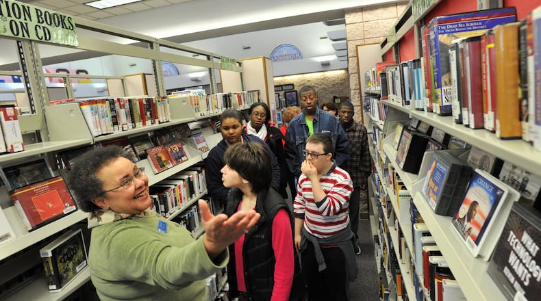 In this 2013 file photo, Karen Harris (left), manager of the Norcross branch of the Gwinnett Public Library System, leads a tour group from Norcross High School. HYOSUB SHIN / HSHIN@AJC.COM