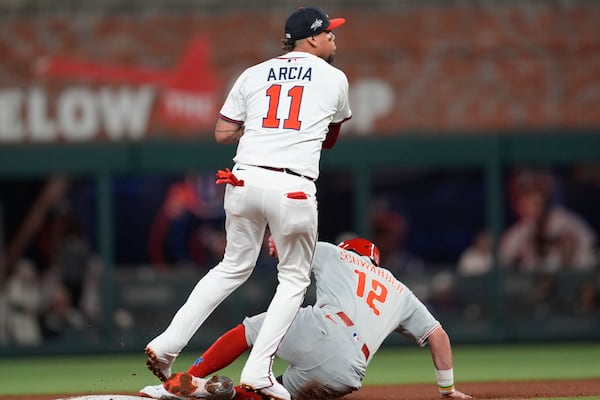 Atlanta Braves shortstop Orlando Arcia (11) makes the tag against Philadelphia Phillies designated hitter Kyle Schwarber (12) in the fifth inning of a baseball game, Wednesday, April 9, 2025, in Atlanta. (AP Photo/Mike Stewart)