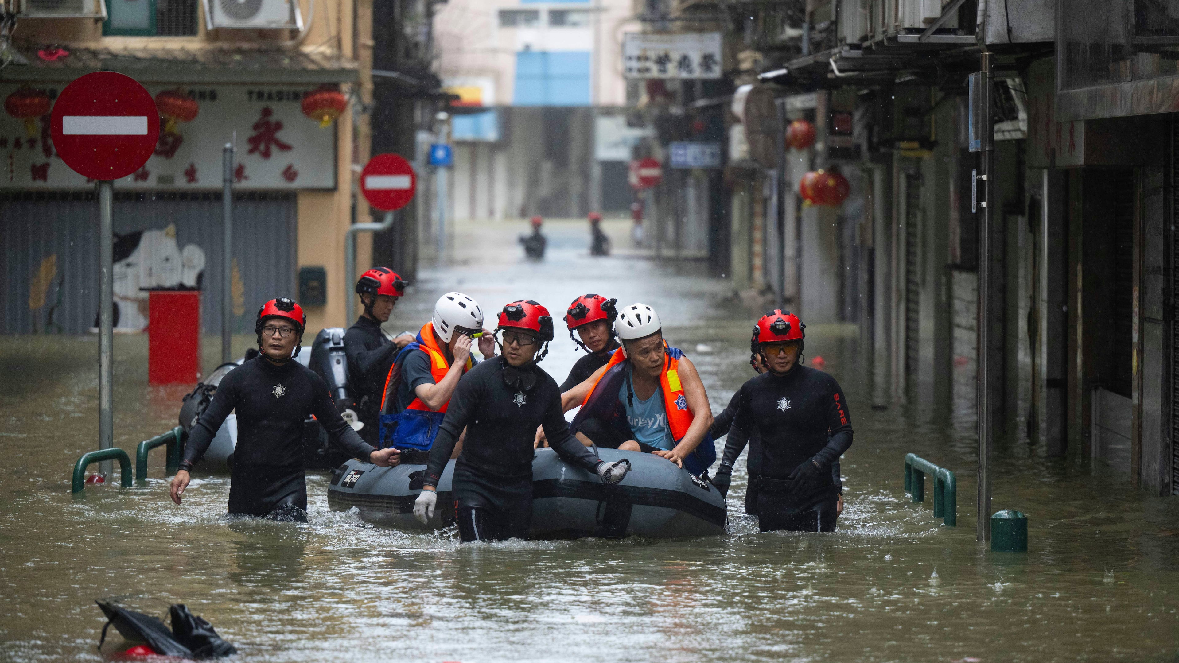 In this photo released by Xinhua News Agency, members from the local customs authority help stranded citizens to evacuate from an inundated street as Super typhoon Ragasa past nearby Macao in southern China, Sept. 24, 2025. (Cheong Kam Ka/Xinhua via AP)