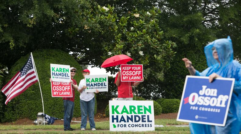 Supporters of Democrat Jon Ossoff and Republican Karen Handel brave the rain Tuesday. (Credit: Jessica McGowan / Getty Images)