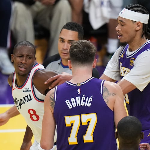 Los Angeles Clippers guard Kris Dunn (8) is pushed by Los Angeles Lakers center Jaxson Hayes (11) after Dunn shoved the ball into Luka Doncic's chest during the second half of an NBA Cup basketball game Tuesday, Nov. 25, 2025, in Los Angeles. (AP Photo/Jae C. Hong)