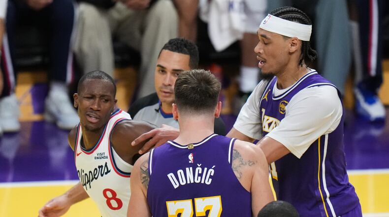 Los Angeles Clippers guard Kris Dunn (8) is pushed by Los Angeles Lakers center Jaxson Hayes (11) after Dunn shoved the ball into Luka Doncic's chest during the second half of an NBA Cup basketball game Tuesday, Nov. 25, 2025, in Los Angeles. (AP Photo/Jae C. Hong)
