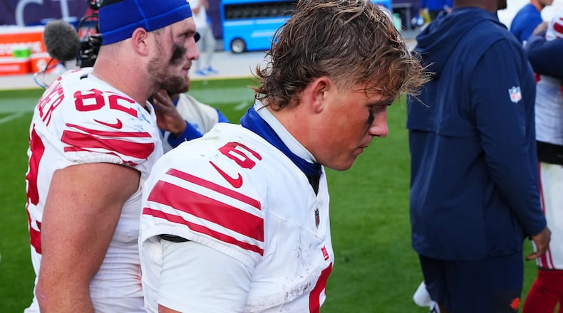 New York Giants tight end Daniel Bellinger, left, and quarterback Jaxson Dart walk off the field after an NFL football game against the Denver Broncos in Denver, Sunday, Oct. 19, 2025. (AP Photo/Jack Dempsey)