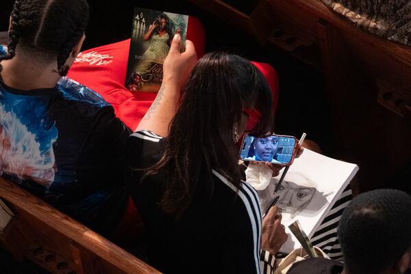 A woman makes a drawing of Tianah Robinson during a celebration of life at Ebenezer Baptist Church on Saturday, April 18, 2026, in Atlanta. The teen was fatally shot two weeks ago at Piedmont Park. (Ben Gray for the AJC)