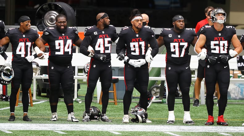 Falcons players join arms for the national anthem to begin the season-opening game against the Seattle Seahawks Sunday, Sept. 13, 2020, at Mercedes-Benz Stadium in Atlanta. (Curtis Compton / Curtis.Compton@ajc.com)