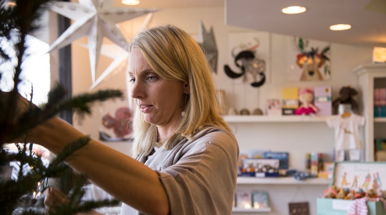 11/22/2017, Sandy Springs, GA - Brooke Henze, of Sandy Springs, places stringed lights onto a Christmas tree inside of her store, The Swell Shop, Wednesday, November 22, 2017. Brooke spent the day decorating and organizing the shop in order to have it operational for the upcoming Small Business Saturday. The store, which will sell American made textiles and personalized heirloom gifts, started exclusively online in December of 2013. ALYSSA POINTER/ALYSSA.POINTER@AJC.COM