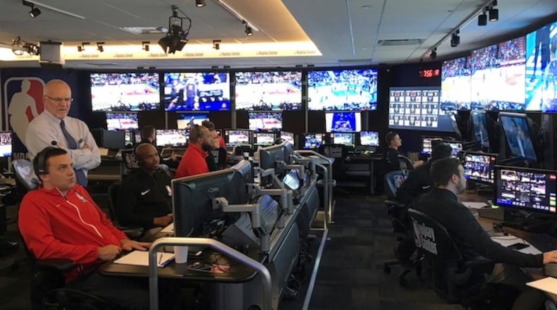 Joe Borgia, NBA Senior Vice President of replay and referee operations, second left, talks to senior replay manager Monte Shubik left, at the National Basketball Association Replay Center in Secacus N.J., Thursday, Nov. 15, 2017. They are in the games, just not at the games. The referees in the NBA's Replay Center are far from the action but yet right in the middle of it, potentially making rulings on the most important plays of the night from their desk in a New Jersey office park. NBA referee Dedric Taylor is third from left. (AP Photo/Brian Mahoney)