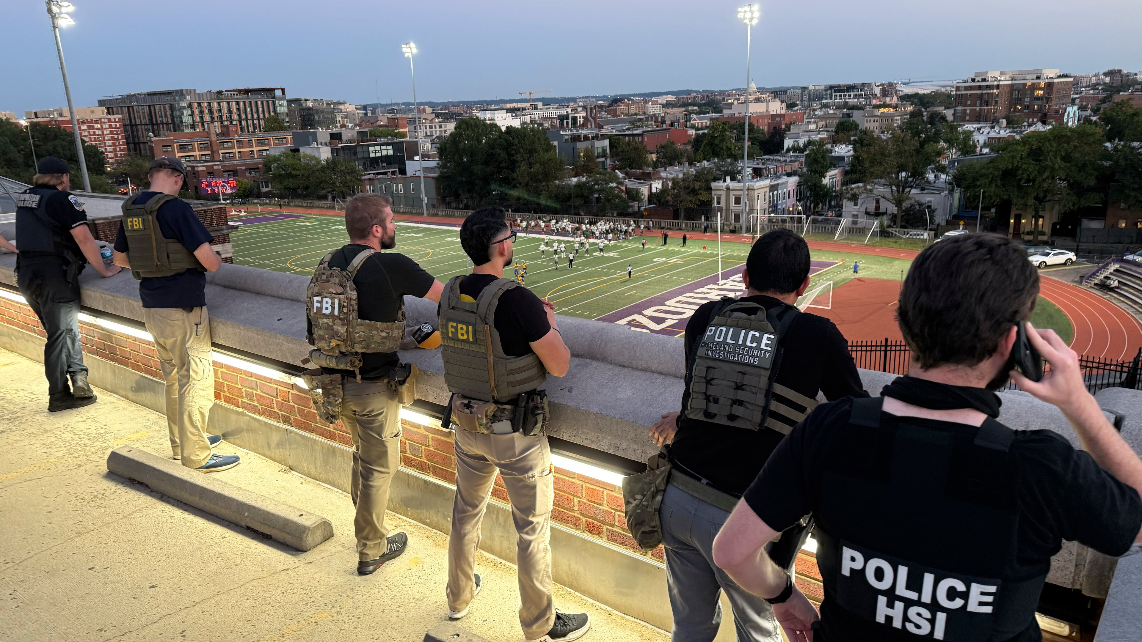 Officers from Metropolitan Police Department, FBI, and Homeland Security Investigations (HSI), are seen monitoring a football game between Bell Multicultural and Archbishop Carroll, Friday, Sept., 12, 2025, at Cardozo High School in the Columbia Heights neighborhood in Washington. (AP Photo/Pablo Martinez Monsivais)