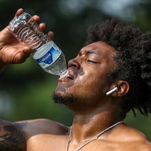 Jacob Jones of Exclusive Training hydrates after working with a client on Tuesday, July 18, 2023, in downtown Atlanta. Although FIFA World Cup matches will be held in the air-conditioned Mercedes-Benz Stadium, most fan events will be outdoors. (John Spink/AJC 2023)