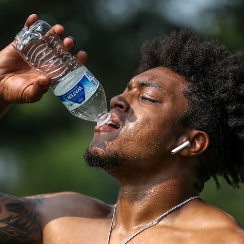 Jacob Jones of Exclusive Training hydrates after working with a client on Tuesday, July 18, 2023, in downtown Atlanta. Although FIFA World Cup matches will be held in the air-conditioned Mercedes-Benz Stadium, most fan events will be outdoors. (John Spink/AJC 2023)