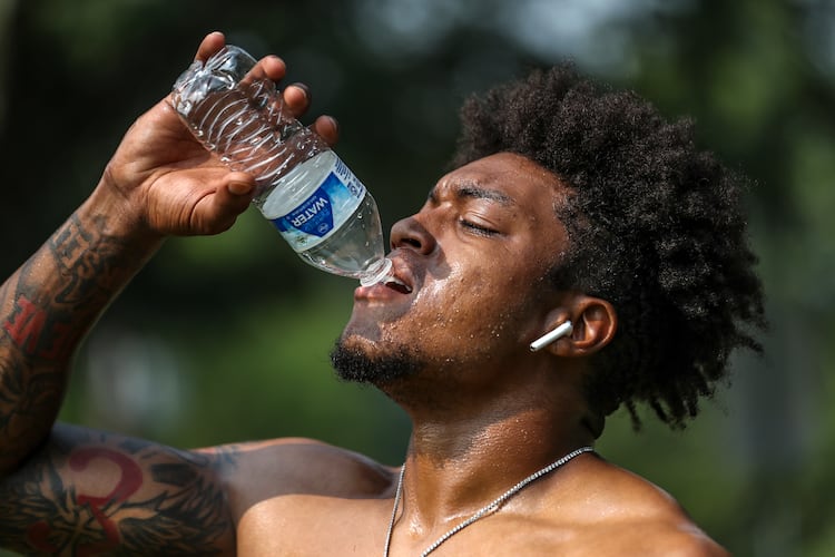 Jacob Jones of Exclusive Training hydrates after working with a client on Tuesday, July 18, 2023, in downtown Atlanta. Although FIFA World Cup matches will be held in the air-conditioned Mercedes-Benz Stadium, most fan events will be outdoors. (John Spink/AJC 2023)