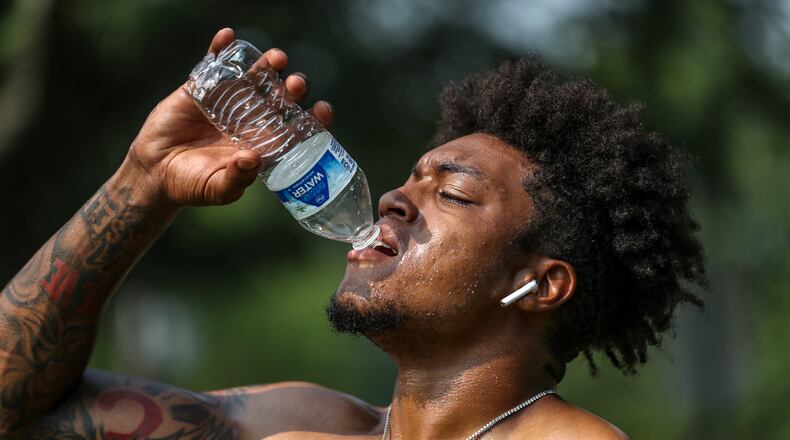 Jacob Jones of Exclusive Training hydrates after working with a client on Tuesday, July 18, 2023, in downtown Atlanta. Although FIFA World Cup matches will be held in the air-conditioned Mercedes-Benz Stadium, most fan events will be outdoors. (John Spink/AJC 2023)