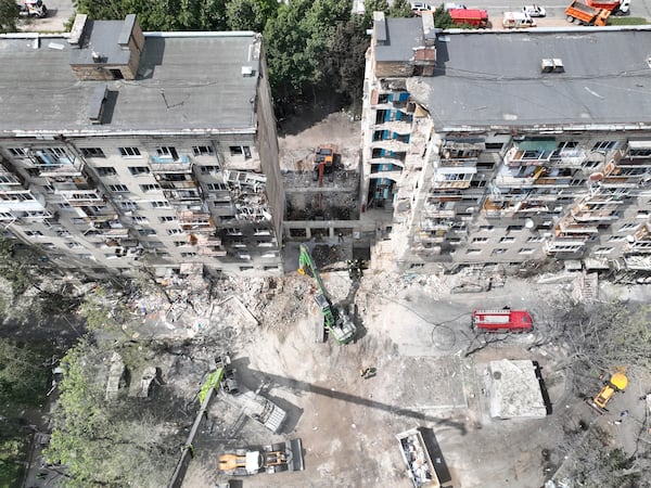 In this aerial photo provided by the Ukrainian Emergency Service, searchers sift through the wreckage on the site of Russia's Tuesday deadly missile attack that ruined a multistory residential building in Kyiv, Ukraine, Wednesday, June 18, 2025. (Ukrainian Emergency Service via AP)