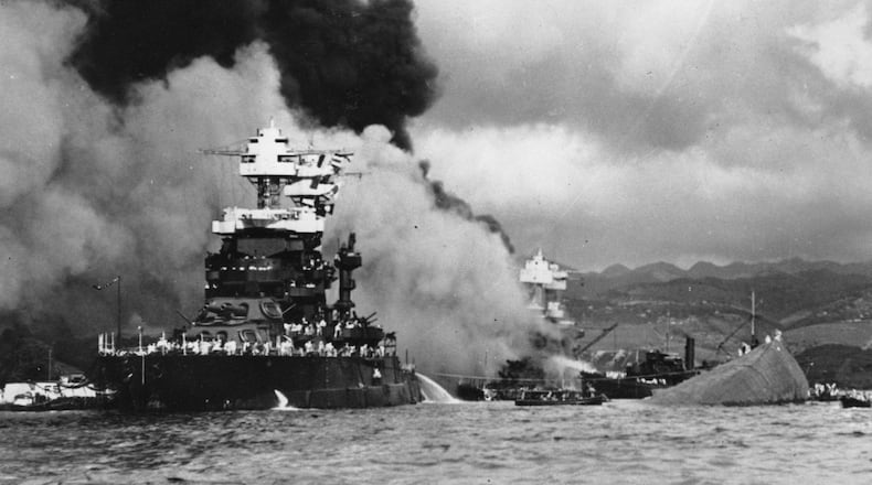 Part of the hull of the capsized USS Oklahoma is seen at right beside the the USS Maryland in Pearl Harbor, Hawaii. Georgian Gene Blanchard died in the attack on the Oklahoma, which quickly rolled over after being hit by a number of torpedoes from Japanese attackers on Dec. 7, 1941. (AP Photo/U.S. Navy, File)