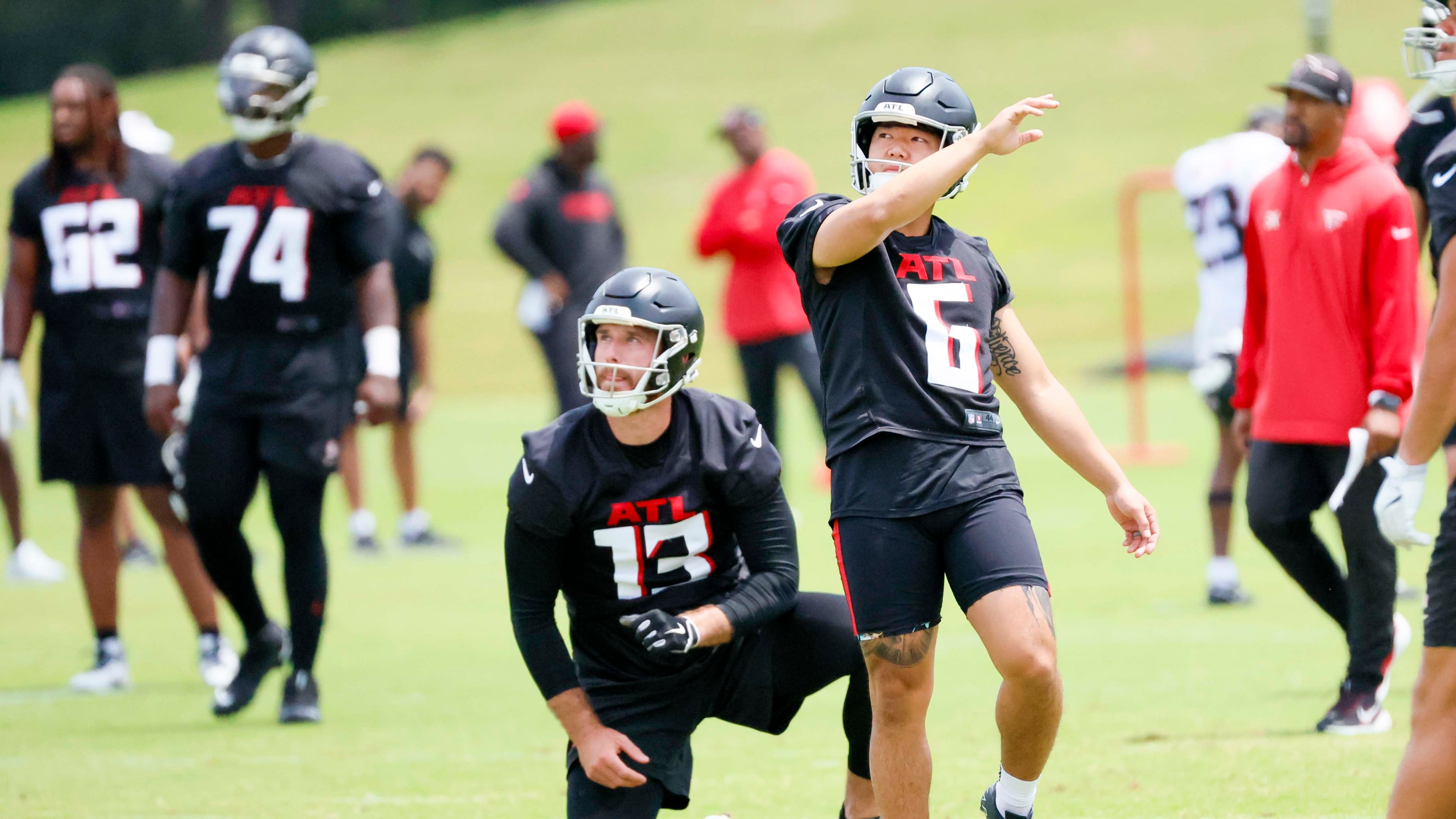 Atlanta Falcons placekicker Younghoe Koo (right center) and punter Bradley Pinion (center, kneeling) practice field goals during minicamp Wednesday, June 11, 2025, in Flowery Branch. (Miguel Martinez/AJC)
