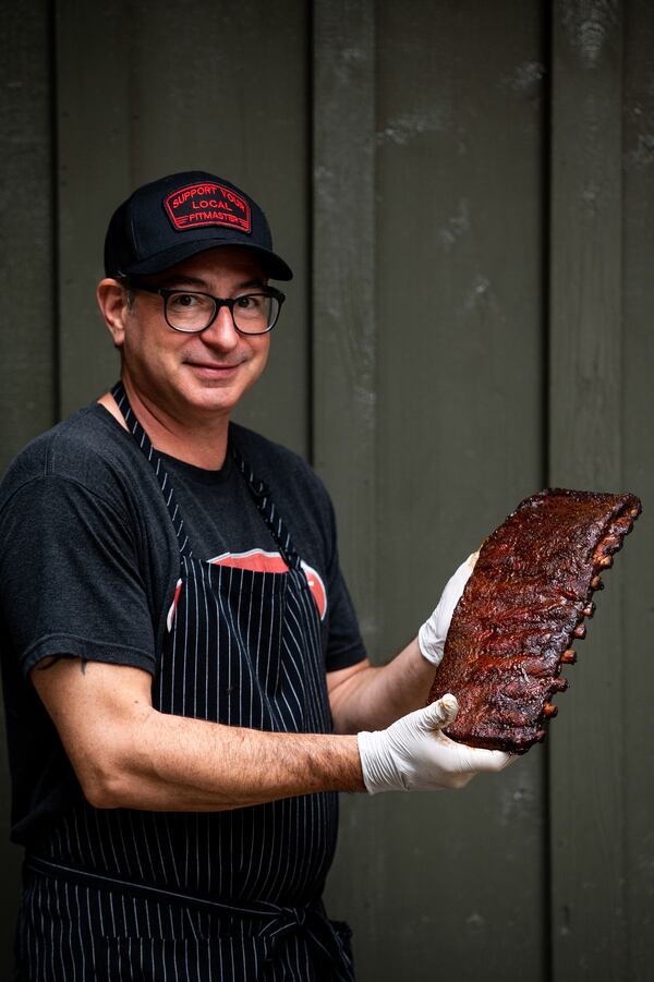 Man holding a rack of smoked ribs.
