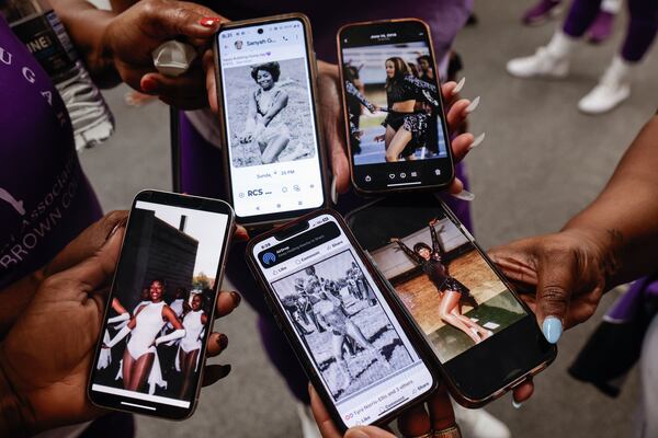 Members of the Morris Brown College Bubbling Brown Sugar alumni dance team share old photos of themselves from their undergraduate days in the band during homecoming practice in Atlanta on Tuesday, Oct. 7, 2025. (Natrice Miller/AJC)