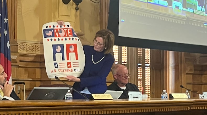 State Election Board member Janice Johnston holds up a sign encouraging only U.S. citizens to vote during a State Election Board meeting Wednesday at the Georgia Capitol in Atlanta. The board voted 3-1 to email the sign to all 159 counties, encouraging election officials to post the sign at polling locations and election offices. Voting rights groups say they’re concerned the sign could discourage immigrants who have become citizens from registering to vote in a state that already has stringent voting laws.