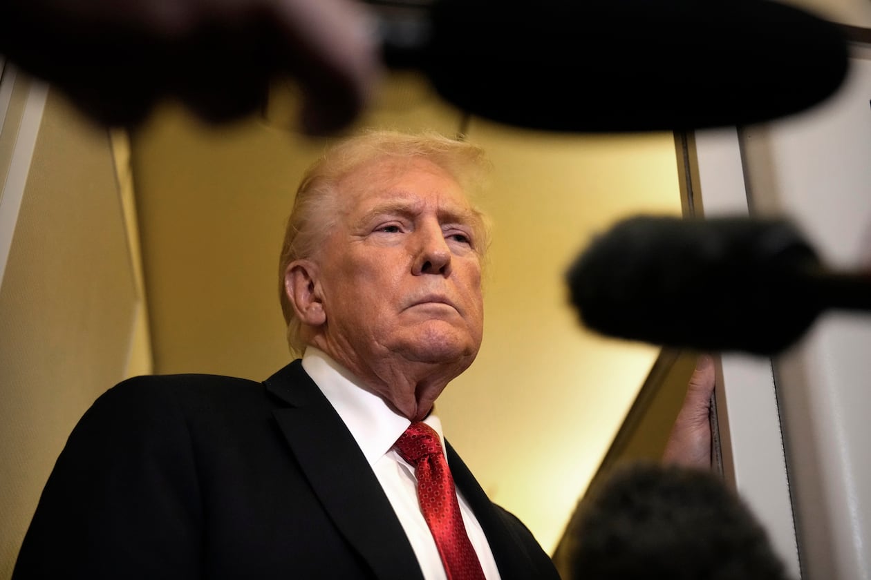 President Donald Trump speaks to reporters aboard Air Force One, Sunday, Oct. 19, 2025, en route to Joint Base Andrews, Md., as he returns from a trip to Florida. (AP Photo/Mark Schiefelbein)
