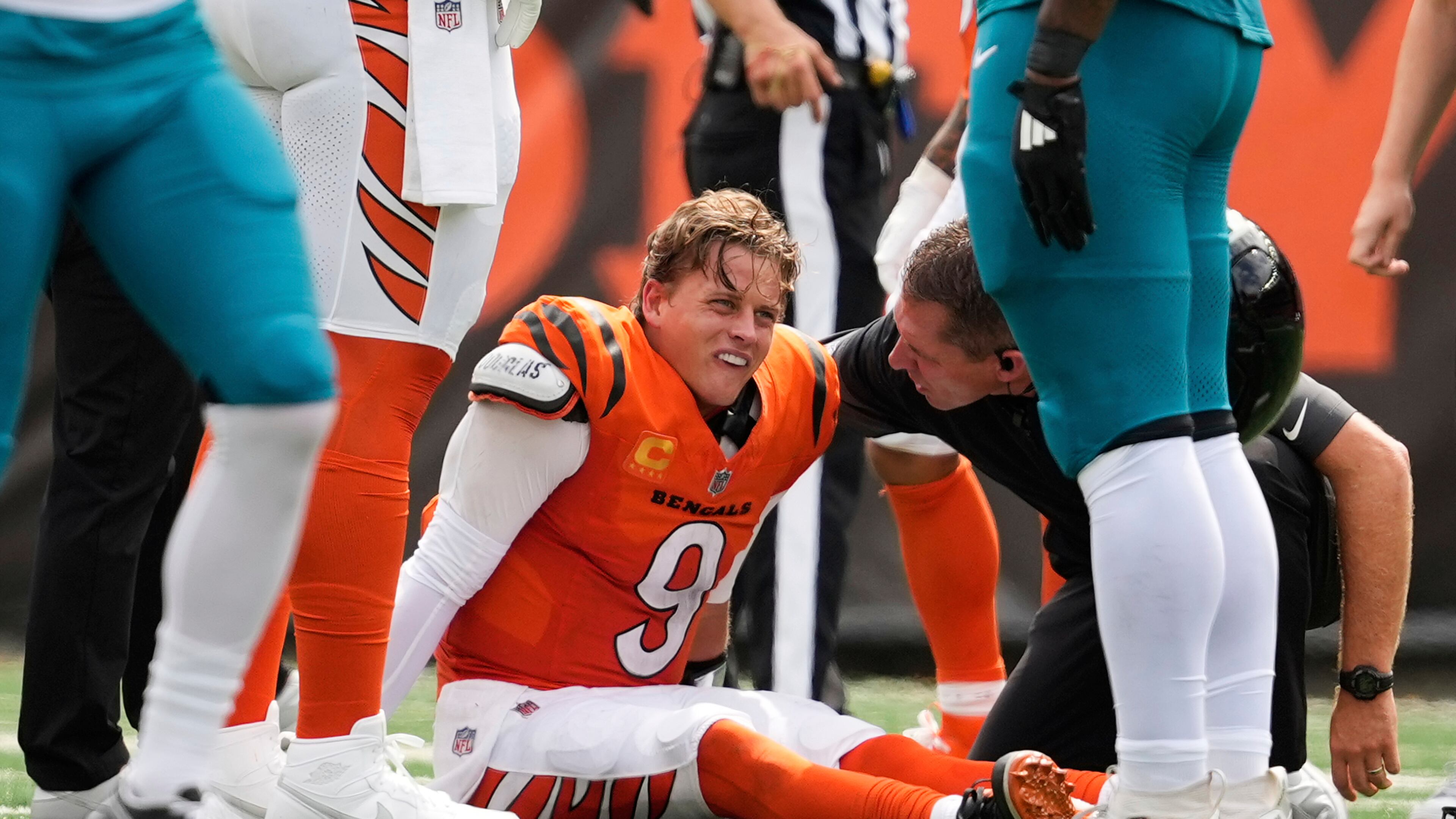 Cincinnati Bengals quarterback Joe Burrow (9) grimaces aft being sacked by Jacksonville Jaguars defensive tackle Arik Armstead (91) during the first half of an NFL football game, Saturday, Sept. 14, 2024, in Cincinnati. (AP Photo/Carolyn Kaster)