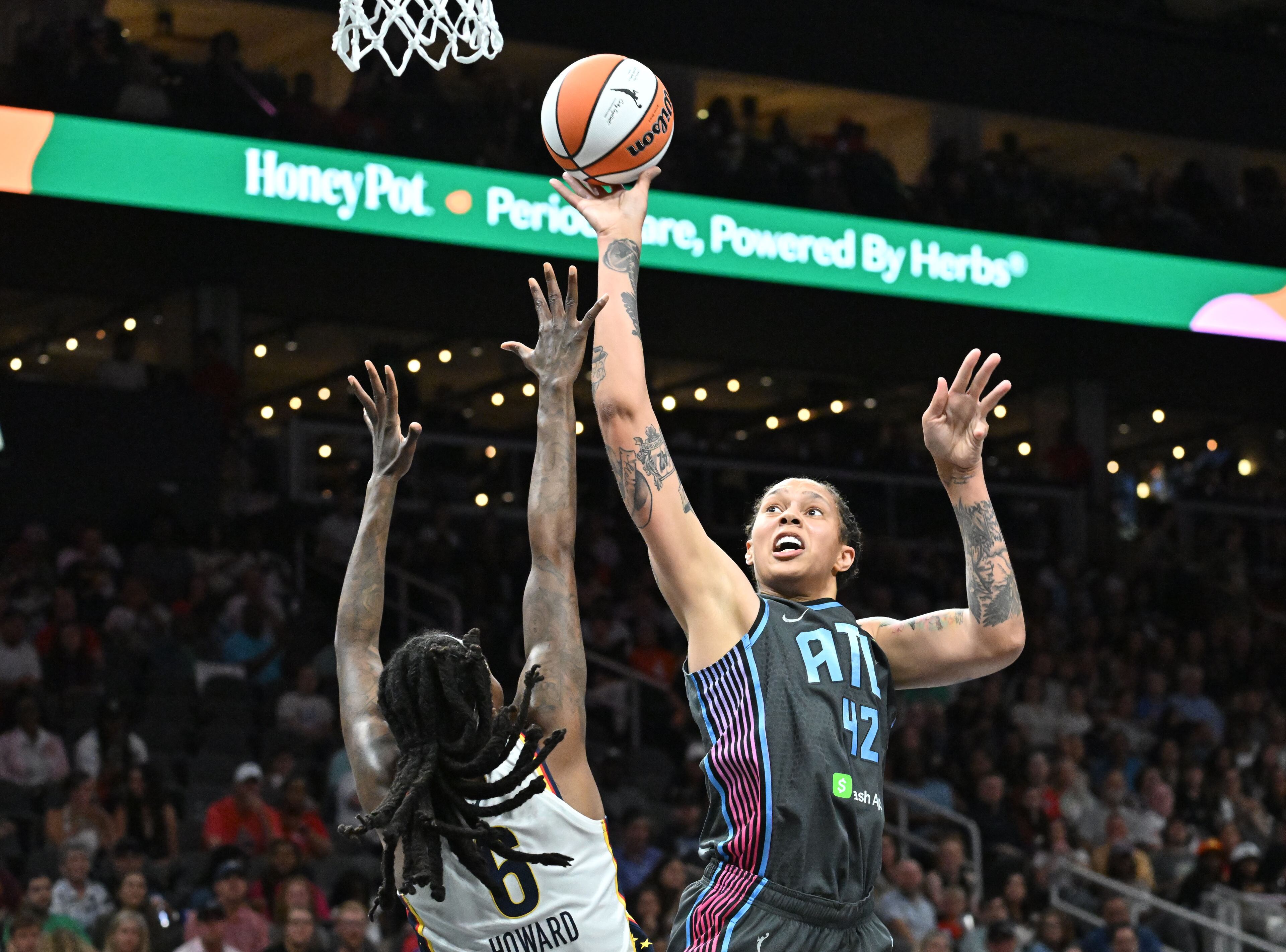 Dream center Brittney Griner shoots over Fever forward Natasha Howard during the Atlanta Dream’s home opener at State Farm Arena on Thursday. Griner saw limited time on the floor because of foul trouble. (Hyosub Shin/AJC)