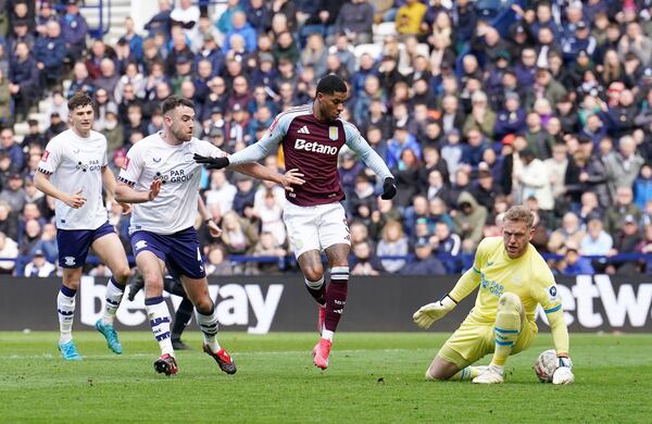 Preston North End goalkeeper David Cornell, right, saves at the feet of Aston Villa's Marcus Rashford during the English FA Cup quarter final soccer match at Deepdale, Preston, England, Sunday, March 30, 2025. (Martin Rickett/PA via AP)