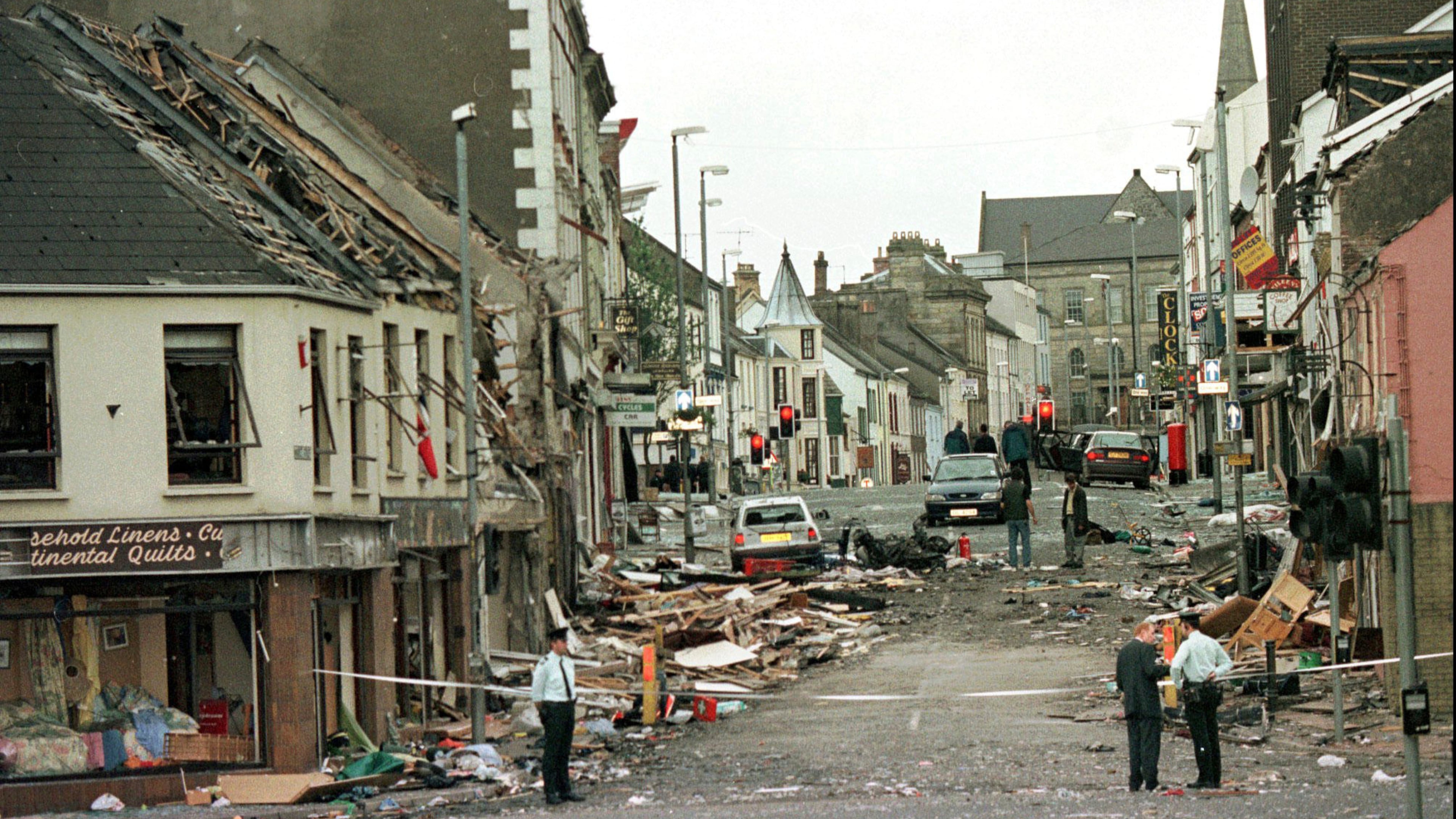 FILE - Royal Ulster Constabulary Police officers stand on Market Street, the scene of a car bombing in the centre of Omagh, Co Tyrone, 72 miles west of Belfast, Northern Ireland, on Aug. 15, 1998. (AP Photo/Paul McErlane, File)