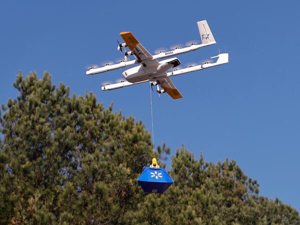 A Wing delivery drone carries a package through the air after taking off from Walmart Supercenter in Woodstock on Wednesday, Dec. 3, 2025. (Natrice Miller/AJC)
