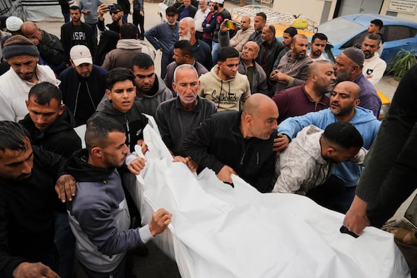 Mourners carry the bodies of three members of Dahouh family, killed when an Israeli army strike hit their tent, before their burial at the hospital in Deir al-Balah, Gaza Strip on Tuesday, April 1, 2025. (AP Photo/Abdel Kareem Hana)
