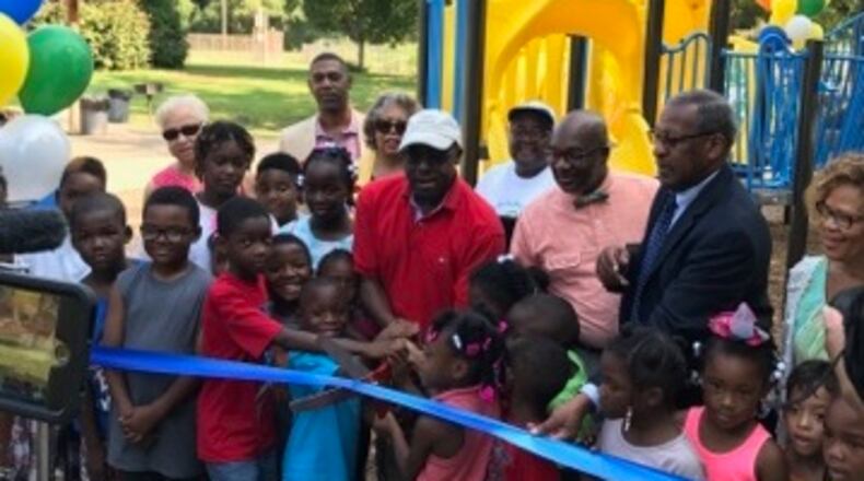 A ribbon-cutting for a new playground at Midway Park near Memorial Drive was held July 27. DeKalb Commissioner Larry Johnson is pictured in the center, joined by Commissioner Greg Adams and DeKalb Interim Parks Director Marvin Billups.