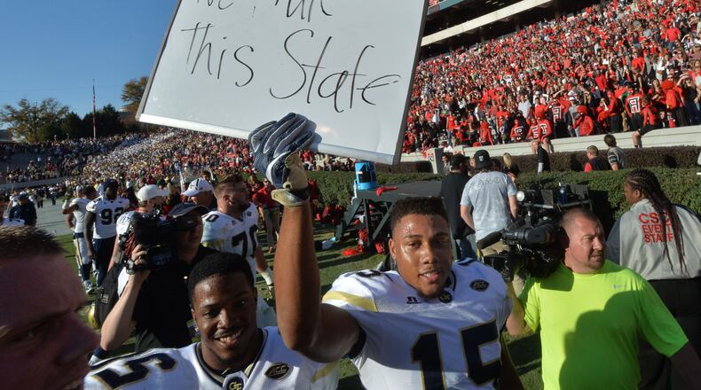 Georgia Tech defensive back A.J. Gray (15) holds a sign to celebrate their 28-27 win over Georgia at Sanford Stadium on Saturday, November 26, 2016. HYOSUB SHIN / HSHIN@AJC.COM