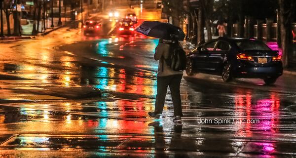 Pedestrians deal with wet weather at Luckie Street and Centennial Olympic Park Drive. JOHN SPINK / JSPINK@AJC.COM