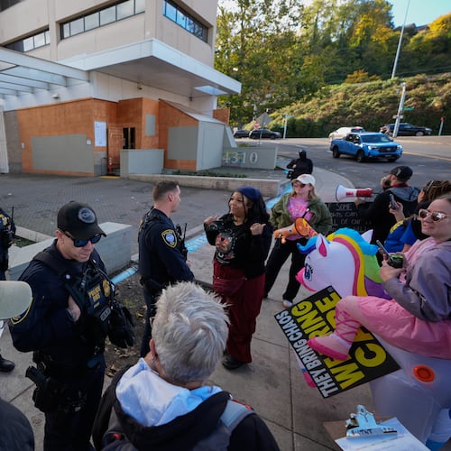 Law enforcement officers talk with protesters outside a United States Immigration and Customs Enforcement (ICE) facility in Portland, Ore., Monday, Oct. 20, 2025. (AP Photo/Jenny Kane)