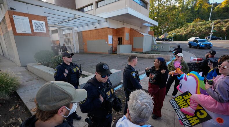 Law enforcement officers talk with protesters outside a United States Immigration and Customs Enforcement (ICE) facility in Portland, Ore., Monday, Oct. 20, 2025. (AP Photo/Jenny Kane)