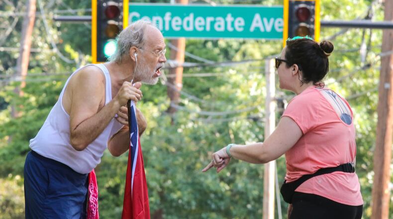 Confederate Flag runner, Alan Keck (left) debates Grant Park resident, Katie Kurumada (right) about the petition to change the name of Confederate Avenue on Tuesday, Aug. 15, 2017 on Boulevard. The Atlanta City Council will consider a proposal pushed by residents to rename the street. JOHN SPINK/JSPINK@AJC.COM