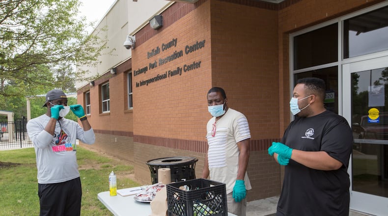 Working to distribute food at DeKalb County’s Exchange Park Recreation Center, William Smith, the center’s director ( left) Nicholas Dixon, a counselor at the center, and assistant director Leonard Allen provide fresh fruit, juice and cookies as well as coloring books and crayons for public school students Wednesday, April 8, 2020. Jenni Girtman for The Atlanta Journal-Constitution