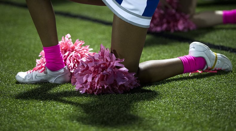 A McCallum cheerleader kneels during the playing of the national anthem before the start of the Knights’ football game against Austin High on Oct. 5.