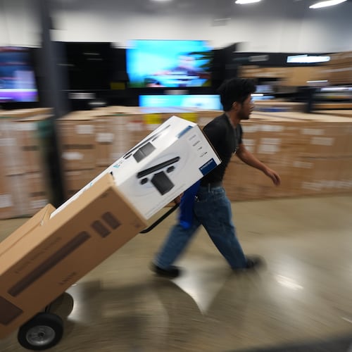 A Best Buy employee hauls early Black Friday sale items at Best Buy Thursday, Nov. 20, 2025, in San Diego. (AP Photo/Gregory Bull)