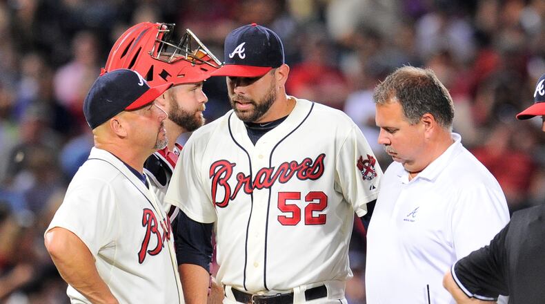 Atlanta Braves manager Fredi Gonzalez (33) removes relief pitcher Jordan Walden (52) from the game after Walden is hit by a line drive off his pitching hand against the Miami Marlins during the ninth inning at Turner Field on Aug. 10, 2013. The Marlins defeated the Braves 1-0.