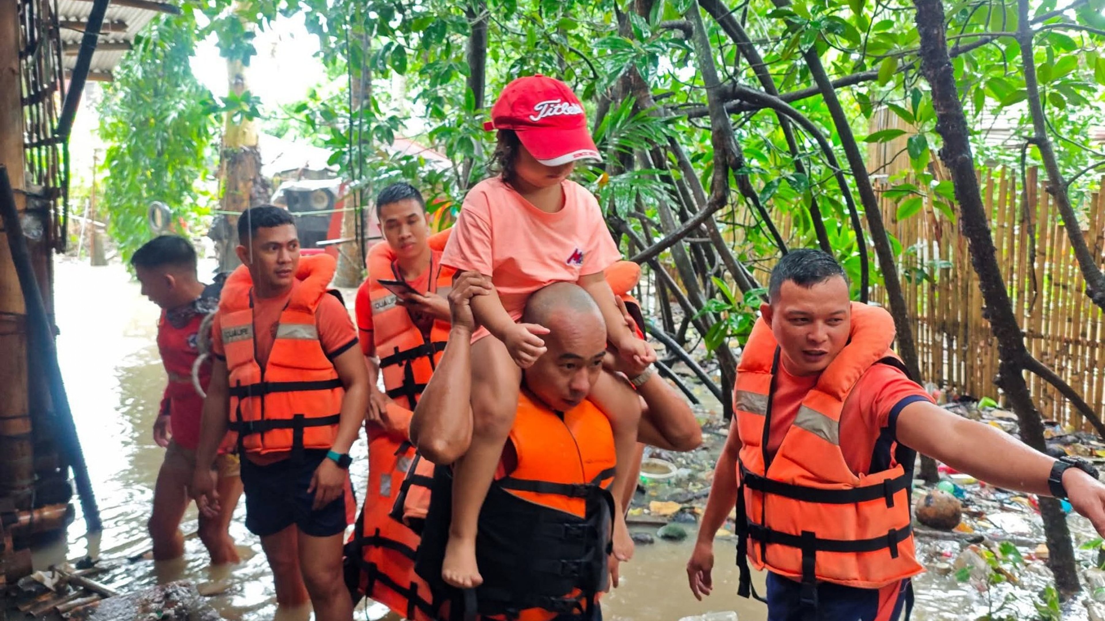 In this handout provided by the Philippine Coast Guard, rescuers move residents to safer grounds as floods rise due to Tropical Storm Bualoi in Bacolod city, Negros Occidental province, Philippines Friday, Sept. 26, 2025. (Philippine Coast Guard via AP)