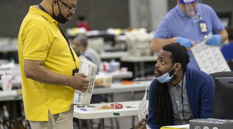 Fulton County employees count mail-in ballots at the Georgia World Congress Center in Atlanta the day after the state’s June 9 primary. (ALYSSA POINTER / ALYSSA.POINTER@AJC.COM)
