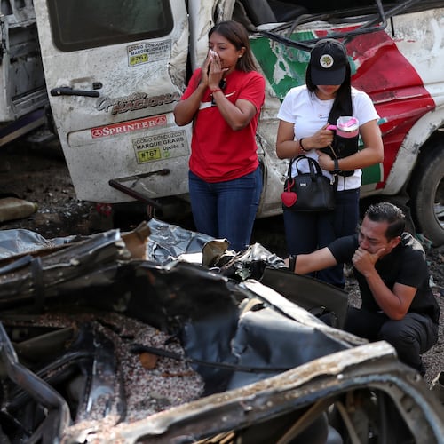 Relatives of victims pay respects at the site of an attack on the Pan-American Highway in Cajibio, Colombia, Sunday, April 26, 2026, where at least a dozen people were killed in an attack authorities blamed on dissident groups of the former FARC rebels. (AP Photo/Santiago Saldarriaga)