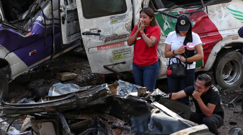 Relatives of victims pay respects at the site of an attack on the Pan-American Highway in Cajibio, Colombia, Sunday, April 26, 2026, where at least a dozen people were killed in an attack authorities blamed on dissident groups of the former FARC rebels. (AP Photo/Santiago Saldarriaga)